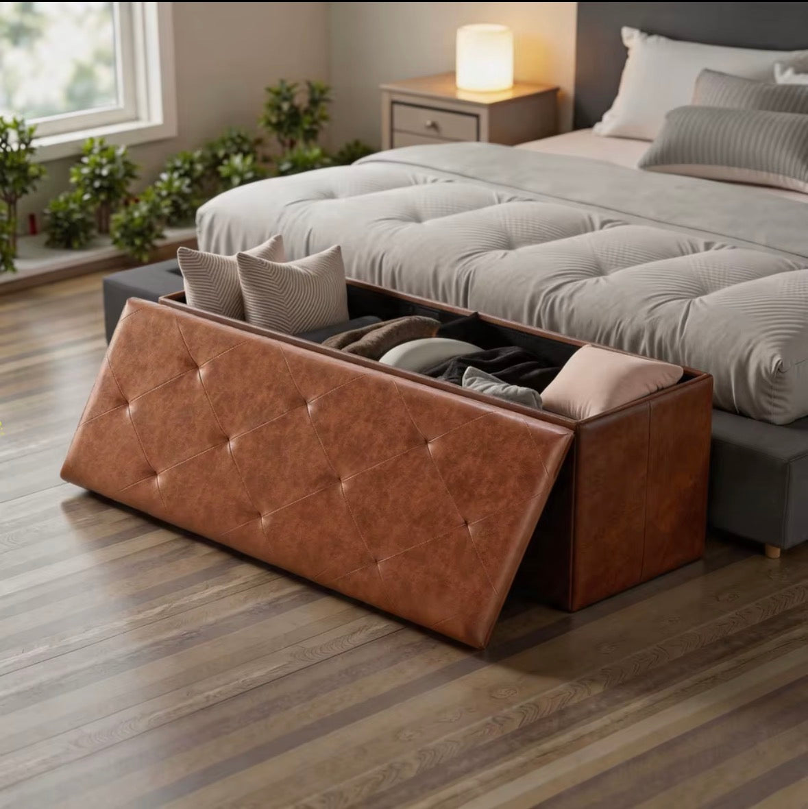 RoomWave brown FoldAway storage ottoman open beside a bed
